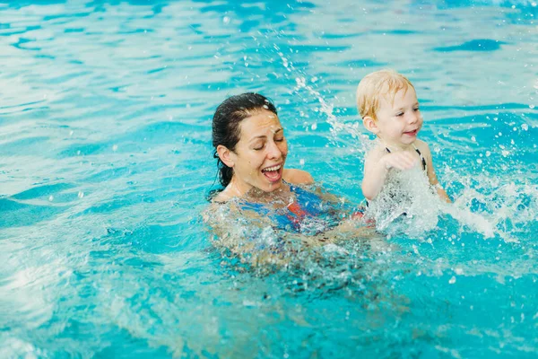 Schwimmbad. Mutter bringt kleinem Kind das Schwimmen im Pool bei. — Stockfoto