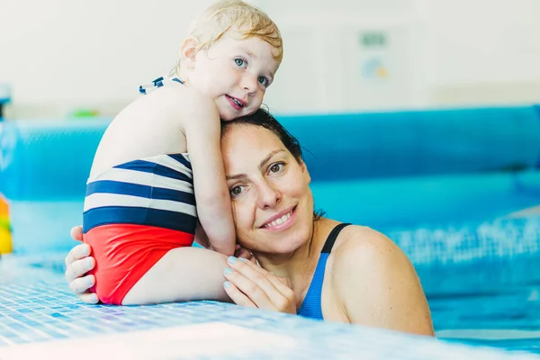 Bazén. Máma učí mladé dítě plavat v bazénu. — Stock fotografie