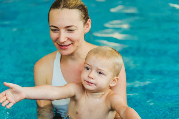 Bazén. Máma učí mladé dítě plavat v bazénu. — Stock fotografie