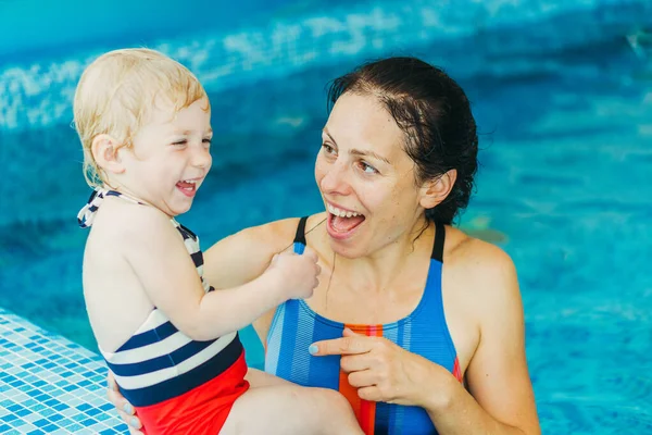 Piscina. Mamma insegna a un bambino a nuotare in piscina . — Foto Stock