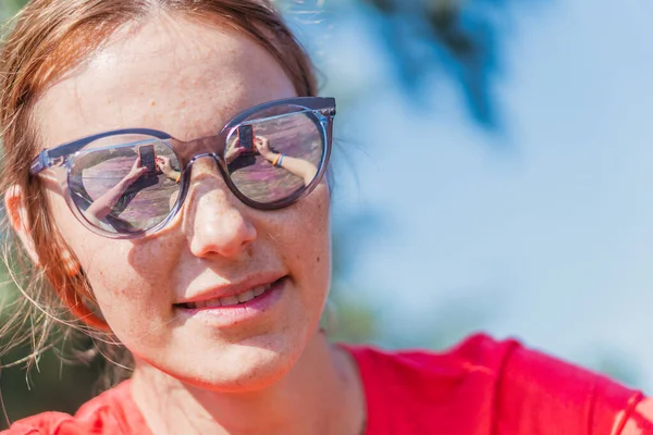 Handy. Eine Frau mit Sonnenbrille blickt auf ein Handy. — Stockfoto