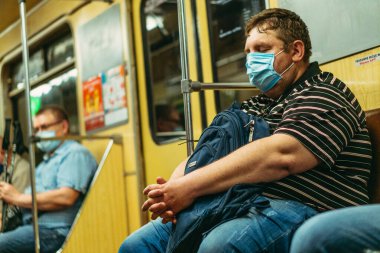 KIEV, UKRAINE - Haziran 09. 2020 yılı. Koronavirüs salgını sırasında Kiev metrosunun çalışması. Koruyucu tıbbi maskeli yolcular.