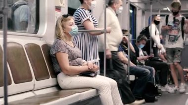 KIEV, UKRAINE - Haziran 09. 2020 yılı. Koronavirüs salgını sırasında Kiev metrosunun çalışması. Koruyucu tıbbi maskeli yolcular.