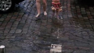 Su baskını. Şiddetli yağmurdan sonra insanlar su birikintilerini ve su basan caddeleri geçtiler..