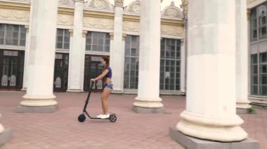 Elektrikli scooter. Genç bir kadın elektrikli scooter kullanıyor..