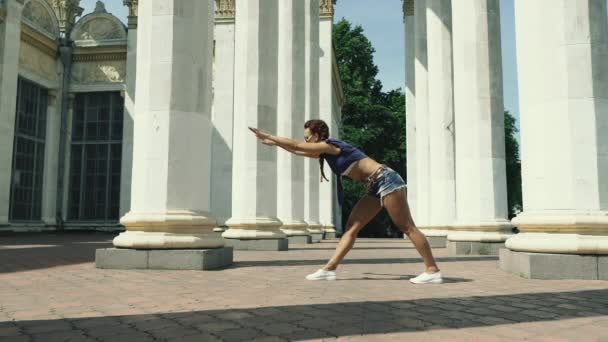 街上的一个女人在做伸展肌肉的运动 — 图库视频影像