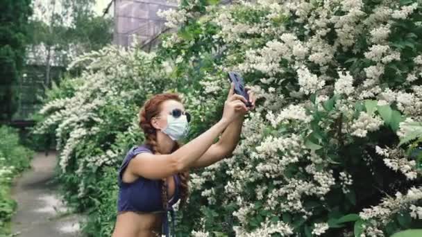 Medizinische Maske Eine Frau Medizinischer Maske Nimmt Blumen Aufs Smartphone — Stockvideo