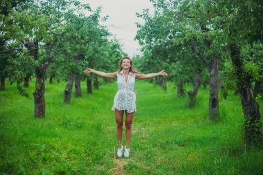 Yolculuk. Yeşil bir parkta bir kız yürüyor.