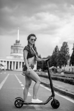 Elektrikli scooter. Genç bir kadın elektrikli scooter kullanıyor..