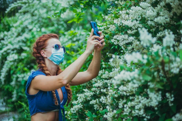 Lékařská Maska Žena Lékařské Masce Bere Květiny Smartphone — Stock fotografie