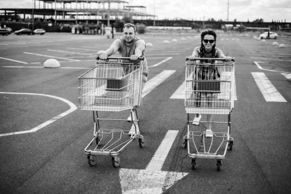 超级市场推车 一个男人和一个女人开着一辆超市推车 — 图库照片
