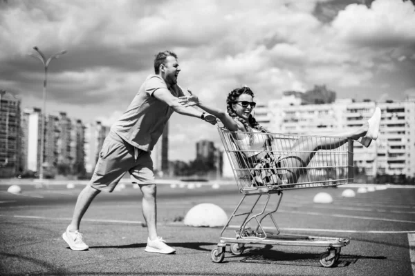 スーパートロリー 男はスーパーマーケットのカートに女性を運ぶ — ストック写真