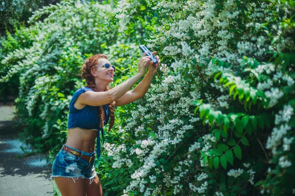 Smartphone Una Mujer Joven Toma Flores Teléfono Inteligente — Foto de Stock