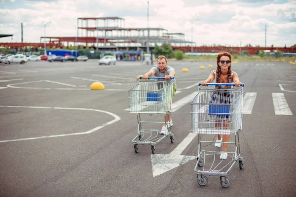 트롤리 남녀가 슈퍼마켓 전차를 운전하고 — 스톡 사진