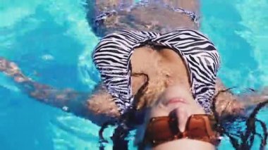 Yüzme havuzu. Havuzda mayo giymiş bir kadın yüzüyor..