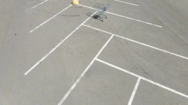 Alışveriş arabası. Boş bir otoparkta bir alışveriş arabası duruyor..