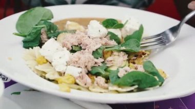 Yiyecekler. Bir kadın ton balıklı makarna yiyor..