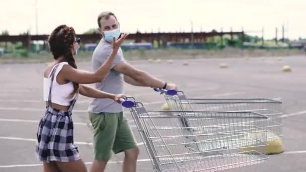 Supermarktwagen Een Man Een Vrouw Met Een Medisch Masker Rijden — Stockvideo