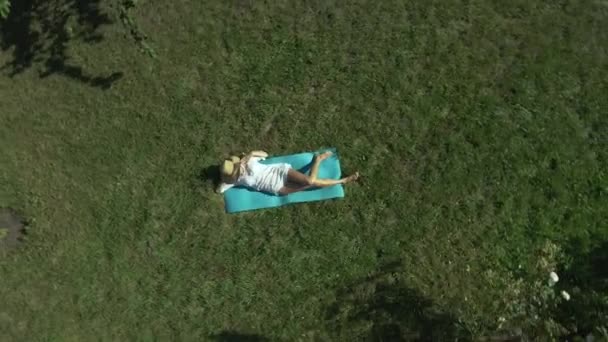 Zonnebaden Een Vrouw Zonnebaden Een Groen Grasveld Buurt Van Een — Stockvideo