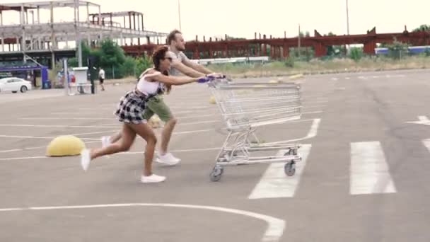 スーパートロリー 男と女はスーパーマーケットのカートで競争している — ストック動画