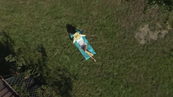 Zonnebaden Een Vrouw Zonnebaden Een Groen Grasveld Buurt Van Een — Stockvideo