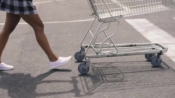 スーパートロリー 医療マスクの女性はスーパーマーケットのトロリーを運ぶ — ストック動画