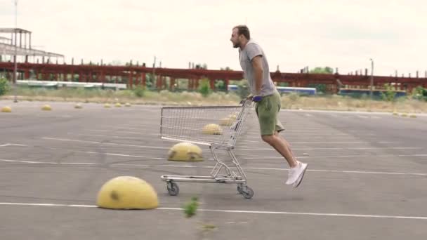 スーパートロリー 男はスーパーマーケットのカートに乗る — ストック動画