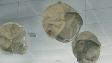 Virüs. Devasa tıbbi maske modelleri tavandan süs gibi sarkıyor..