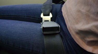 Emniyet kemeri. Kadın eli uçakta emniyet kemerini bağlar..