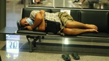 Virüs. Tıbbi maskeli bir adam havaalanında uçak bekliyor..