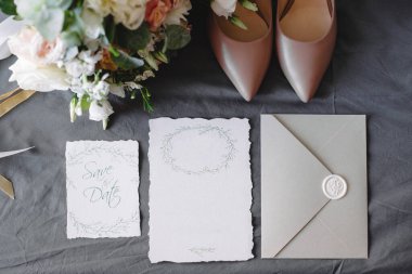 Lüks düğün davetiyeleri, gelin buketi, yüksek topuklu zarif gelin ayakkabıları. Balayı ve düğün konsepti