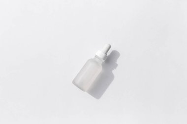 Beyaz arka planda pipeti olan cam şişe. Üst görünüm, düz görünüm, kopyalama alanı.