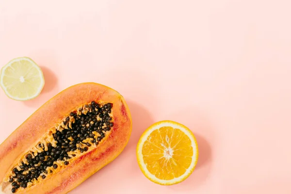Summer tropical composition. Tropical fruits Papaya, orange, lemon on pink background. Summer concept. Flat lay, top view, copy space. High quality photo