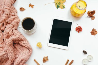 Örgü süveter, tablet, sonbahar yaprakları, beyaz arka planda mumlar. Sonbahar kompozisyonu. Düz konum, üst görünüm, kopyalama alanı
