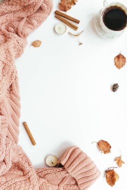 Örgü süveter, bir fincan kahve, sonbahar yaprakları, tarçın çubukları, beyaz arka planda mumlar. Sonbahar kompozisyonu. Düz konum, üst görünüm, kopyalama alanı