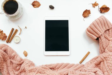 Örgü süveter, tablet, sonbahar yaprakları, beyaz arka planda mumlar. Sonbahar kompozisyonu. Düz konum, üst görünüm, kopyalama alanı