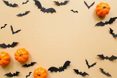 Pastel bej arka planda balkabağı ve yarasalarla Cadılar Bayramı süslemeleri. Cadılar Bayramı konsepti Düz konum, üst görünüm, kopyalama alanı