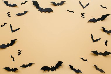 Pastel bej arka planda yarasalar olan Cadılar Bayramı süslemeleri. Cadılar Bayramı konsepti Düz konum, üst görünüm, kopyalama alanı