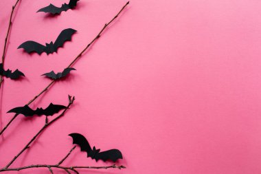 Pembe arka planda yarasalar ve dallarla Cadılar Bayramı süslemeleri. Cadılar Bayramı konsepti Düz konum, üst görünüm, kopyalama alanı