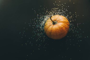 Siyah arka planda balkabağı ve konfeti. Cadılar Bayramı konsepti Düz yatış, üst görünüm