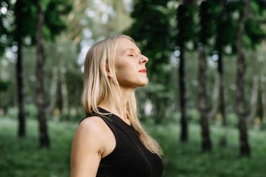 Ormanda temiz hava soluyan rahat bir kadının profili. Büyük zevk..