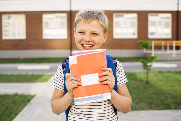 Back to school. Smiling School Boy from elementary school with notebooks and backpack. Education. Day of knowledge.