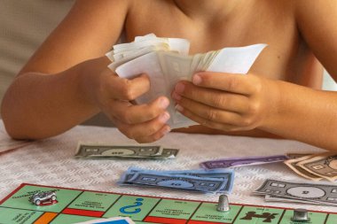 Çocuk yönetimi tekel oyunu oynarken para oynar