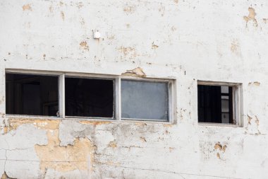 Parçalanmış alçı ve kırık camlar terk edilmiş bir binanın yıkık dökük durumunu gösteriyor.