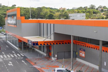 Obramat, a large building materials store in portugal, displays its loading docks and parking area on a clear day
