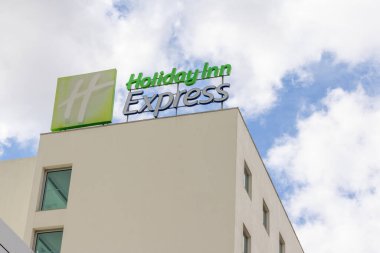Holiday inn express hotel sign standing out against a cloudy sky in alfragide, portugal