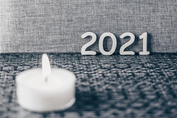 Mutlu Noeller ve mutlu yıllar konsepti, gri arkaplanda ahşap numaralar 2021, mum yeni bir başlangıç sembolü olarak yanan ışıklar.