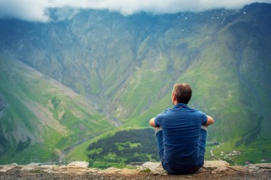 Oturur dağların güzel manzaralı bir dağın üzerinde seyahat. Gürcistan. Kazbegi