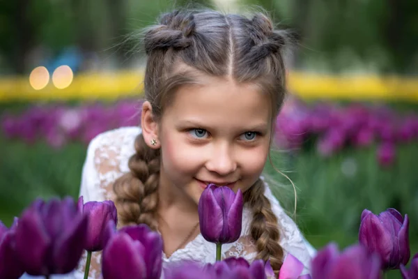 Belle fille renifler une tulipe à l'extérieur — Photo