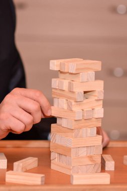 Alternatif risk kavramı, plan ve strateji iş. Bir iş adamı el ahşap blokların bir kule inşa ediyor.